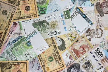 Farklı para birimlerinden ve ülkelerden yüklü miktarda para. Uluslararası nakitin çeşitli arka planında büyük bir yığın var.