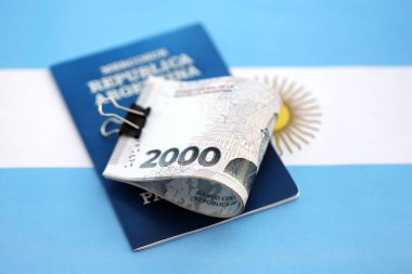 Arjantin pezosu büyük miktarda para ve pasaport Arjantin bayrağına yakın duruyor. Finans ve bankacılık kavramı