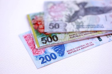 Arjantin pezosu büyük miktarlarda para beyaz masada yakın planda yatıyor. Finans ve bankacılık kavramı