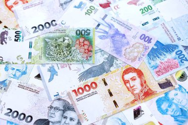 Arjantin pezosu büyük miktarlarda para beyaz masada yakın planda yatıyor. Finans ve bankacılık kavramı
