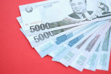 Kuzey Kore büyük miktarlarda para kazandı. Yakın plan kırmızı masada yatıyor. Finans ve bankacılık kavramı