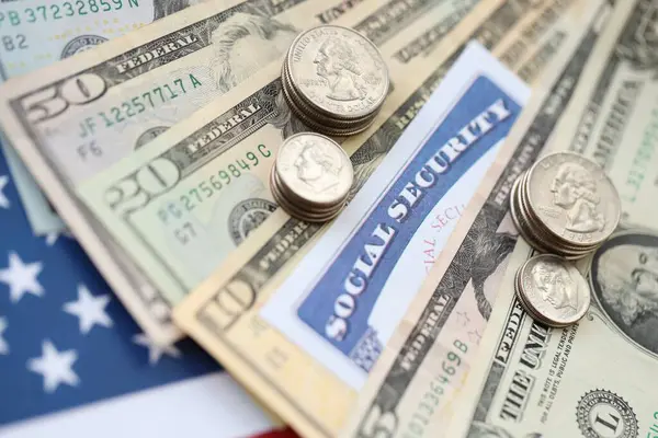 Amerikan doları para faturaları, sosyal güvenlik numarası ve Amerikan bayrağında yakın plan. Vergi ödeme ve sigorta kavramı