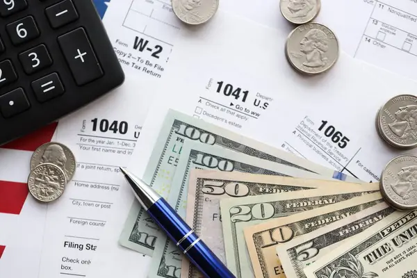 Amerikan Doları. Para banknotları ve vergi formundaki kalem ve hesap makineli paralar boş. Muhasebe ve vergi ödeme dönemi kavramı