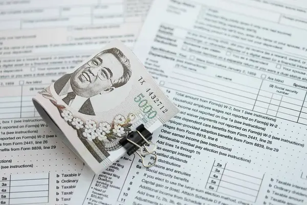 Kuzey Kore büyük miktarlarda para kazandı. Masada vergi formları var. Muhasebe ve vergilendirme kavramı