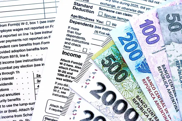 Arjantin pezosu. Büyük miktarda para. Masada, kalem ve vergi formları var.