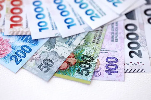 Arjantin pezosu büyük miktarlarda para beyaz masada yakın planda yatıyor. Finans ve bankacılık kavramı