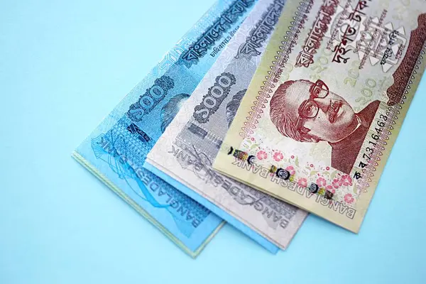 Bangladeşli para banknotları büyük miktarlarda deniz mavisi renkli masaların üzerinde. Finans ve bankacılık kavramı