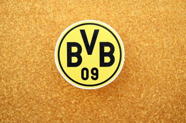 KYIV, UKRAINE - 23 Şubat 2025 Borussia Dortmund futbol kulübü rozeti altın sarısı parıltılı arka plan pankartıyla uzanır