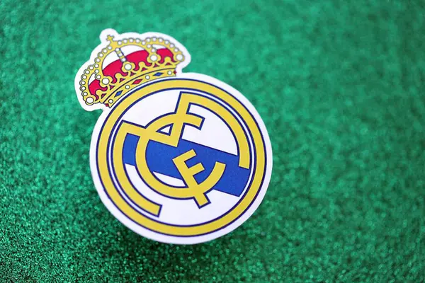 KYIV, UKRAINE - 23 Şubat 2025 Real Madrid CF futbol kulübü rozeti zümrüt yeşili simli arka plan pankartıyla uzanır
