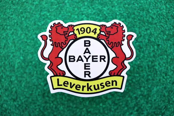 KYIV, UKRAINE - 23 Şubat 2025 Bayer 04 Leverkusen futbol kulübü rozeti zümrüt yeşili simli arka plan pankartıyla uzanır