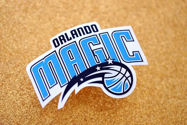 KYIV, UKRAINE - 23 Şubat 2025 Orlando Magic basketbol takımı rozeti altın sarısı parıltılı arka plan pankartıyla uzanır