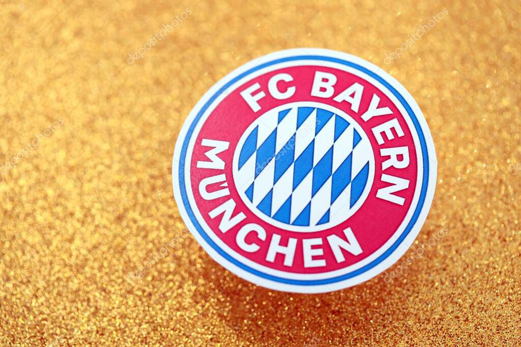 KYIV, UKRAINE - FEBRUARY 23, 2025 FC Bayern Munich football club badge lies on golden yellow glitter background banner