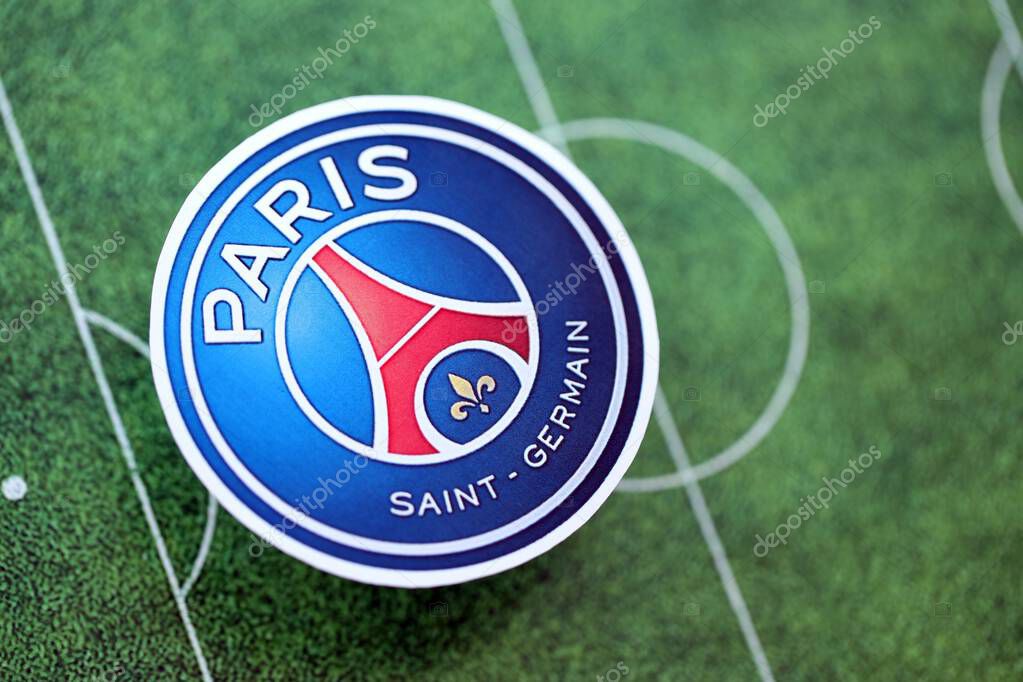 KYIV, UKRAINE - FEBRUARY 23, 2025 Paris Saint Germain FC football club badge lies on soccer field background banner