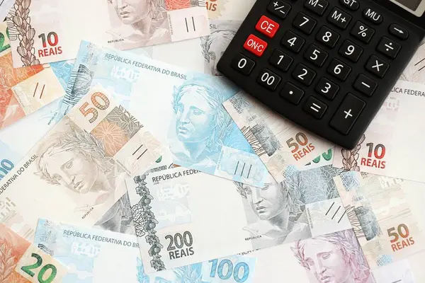Brezilya banknotları ve hesap makinesi. Mevcut Brezilya gerçek para ve hesap makinesi büyük miktarda masada yatıyor. Brezilya 'da vergilendirme ve para konsepti