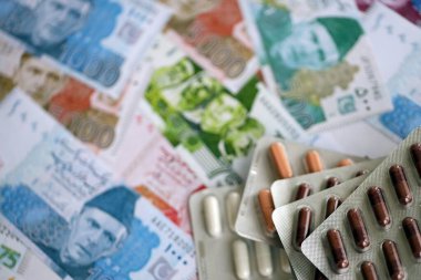 Pakistan banknotları ve ilaç hapları. Pakistan 'ın mevcut para ve uyuşturucu faturaları büyük miktarda masada yatıyor. Pakistan 'da ilaç ve eczane kavramı