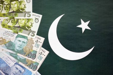 Pakistan 'ın bayrak geçmişi üzerine Pakistan banknotları. Pakistan 'ın mevcut para faturaları büyük miktarlarda pankartta yatıyor. Pakistan 'da ekonomi ve ticaret kavramı