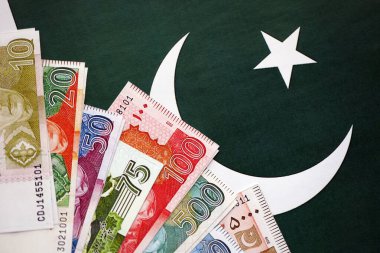 Pakistan 'ın bayrak geçmişi üzerine Pakistan banknotları. Pakistan 'ın mevcut para faturaları büyük miktarlarda pankartta yatıyor. Pakistan 'da ekonomi ve ticaret kavramı