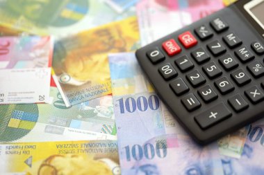 İsviçre frangı banknotları ve hesap makinesi. Mevcut frank para faturaları ve calc büyük miktarda masada yatıyor. İsviçre 'de vergilendirme ve para konsepti