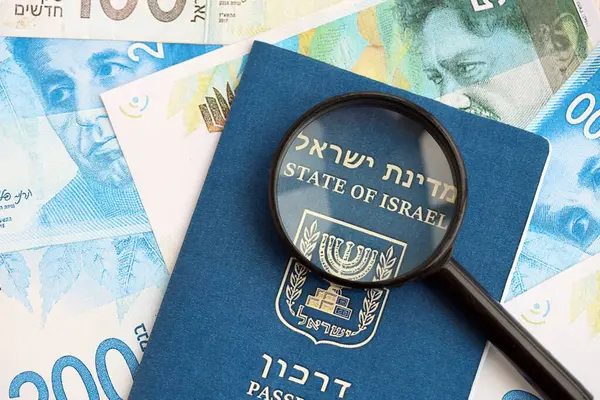 Israel New Shekels banknotları ve Louise 'li pasaport. İsrail 'in mevcut para faturaları ve biyometrik geçiş kartı büyük miktarda masada yatıyor. İsrail 'de seyahat ve tatil kavramı