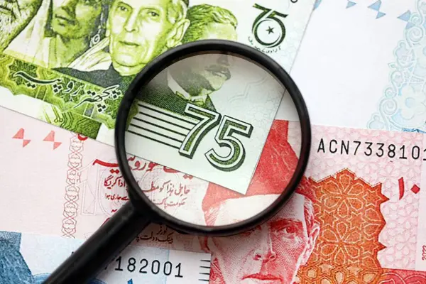 Pakistan banknotları ve büyüteç. Pakistan 'ın mevcut para ve büyüteç faturaları büyük miktarda masanın üzerinde duruyor. Pakistan 'da mali izleme ve vergilendirme kavramı