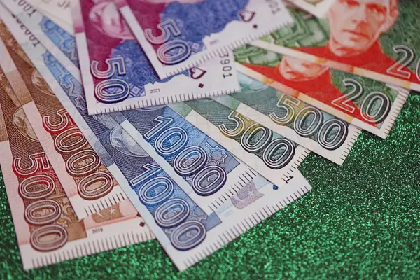 Pakistan parlayan yeşil arka planda banknotlar halinde. Pakistan 'ın mevcut para faturaları büyük miktarda masada yatıyor. Pakistan 'da iş ve yatırım kavramı