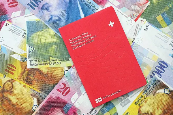 İsviçre frangı banknotları ve pasaportu. Mevcut banknotlar ve biyometrik geçiş kartları büyük miktarda masada yatıyor. İsviçre 'de seyahat ve tatil kavramı