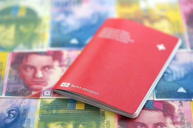 İsviçre frangı banknotları ve pasaportu. Mevcut banknotlar ve biyometrik geçiş kartları masanın üzerinde. İsviçre 'de seyahat ve tatil kavramı