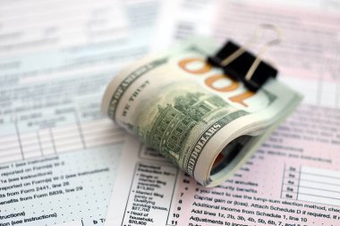 Masada 1040 bireysel gelir vergisi iadesi formuyla birlikte büyük miktarda Amerikan doları banknotları var. ABD 'de vergilendirme ve muhasebe kavramı