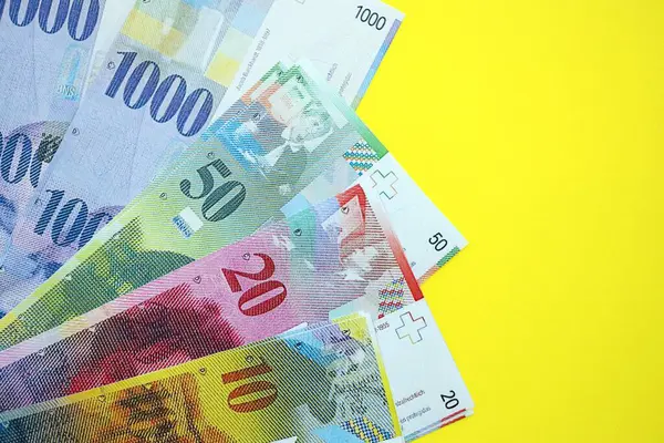 Sarıya İsviçre frangı banknotları. Mevcut frank para faturaları büyük miktarda masada yatıyor. İsviçre 'de iş ve yatırım kavramı