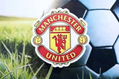 KYIV, UKRAINE - 23 Şubat 2025 Manchester United FC futbol kulübü rozeti futbol arka planında yer almaktadır