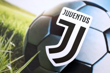 KYIV, UKRAINE - 23 Şubat 2025 Juventus FC futbol kulübü rozeti futbol topu arka planında yer alıyor