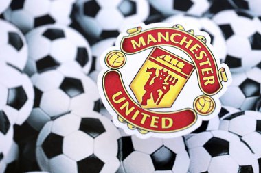 KYIV, UKRAINE - 23 Şubat 2025 Manchester United FC futbol kulübü rozeti futbol topu arka plan pankartıyla yatmaktadır