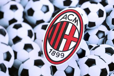 KYIV, UKRAINE - 23 Şubat 2025 AC Milan futbol kulübü rozeti futbol topu arka plan pankartıyla yatmaktadır