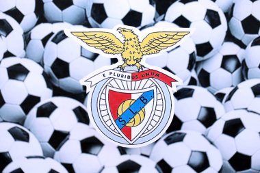 KYIV, UKRAINE - 23 Şubat 2025 Sport Lisboa ve Benfica futbol kulübü rozeti futbol topu arka plan afişinde yatıyor