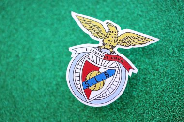 KYIV, UKRAINE - 23 Şubat 2025 Sport Lisboa ve Benfica futbol kulübü rozeti zümrüt yeşili simli arka plan afişinde yer alıyor