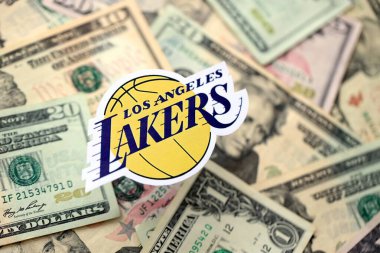 KYIV, UKRAINE - 23 Şubat 2025 Los Angeles Lakers basketbol takımı rozeti Amerikan dolarlarının büyük miktarına yakın.