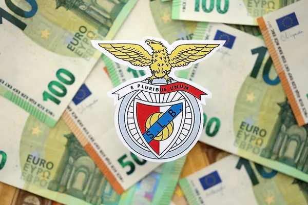 KYIV, UKRAINE - 23 Şubat 2025 Sport Lisboa ve Benfica futbol kulübü rozeti büyük miktarda EURO para banknotlarının üzerinde yatıyor