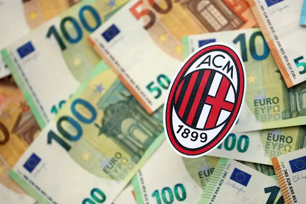 KYIV, UKRAINE - 23 Şubat 2025 AC Milan futbol kulübü rozeti büyük miktarda EURO para banknotları üzerinde yatıyor