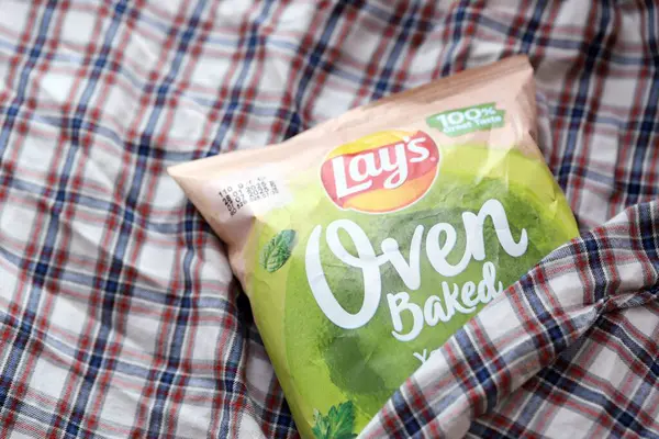 KYIV, UKRAINE - 19 Nisan 2025 Fırında fırında yoğurt ve yeşil patates cipsi ve Lays resmi logosu.