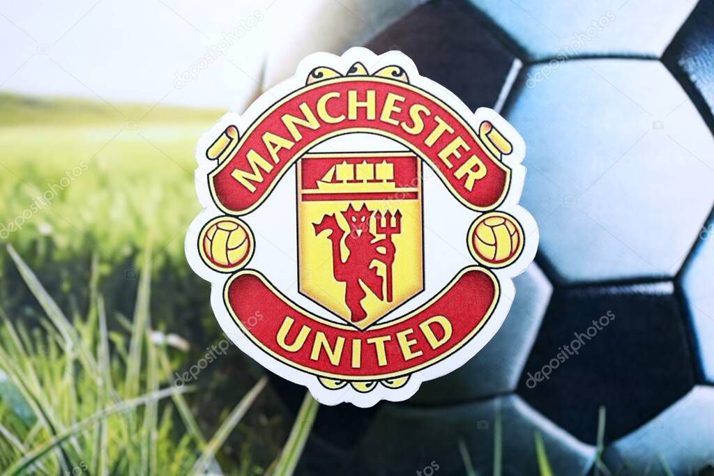 KYIV, UKRAINE - FEBRUARY 23, 2025 Manchester United FC football club badge lies on soccer ball background banner