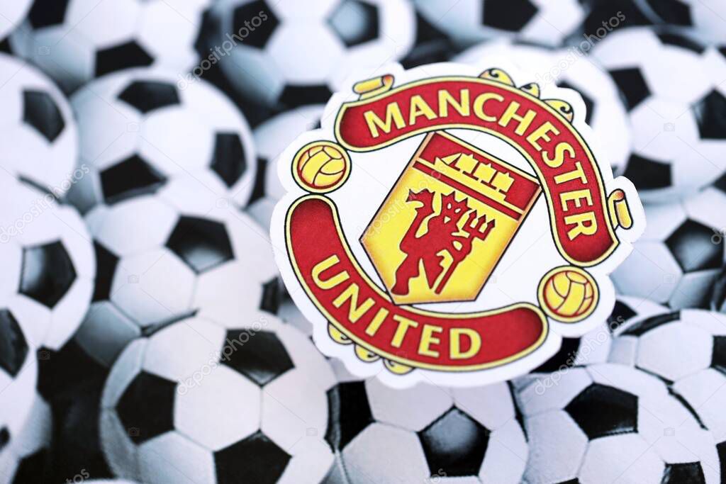 KYIV, UKRAINE - FEBRUARY 23, 2025 Manchester United FC football club badge lies on soccer balls background banner