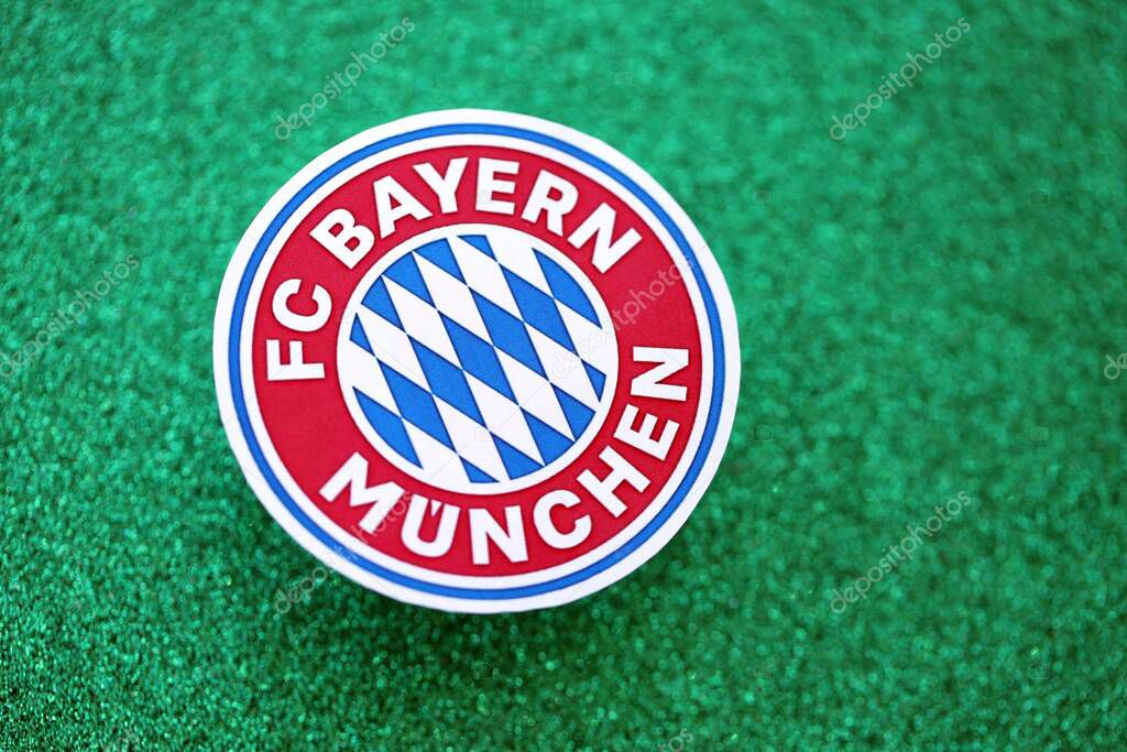 KYIV, UKRAINE - FEBRUARY 23, 2025 FC Bayern Munich football club badge lies on emerald green glitter background banner