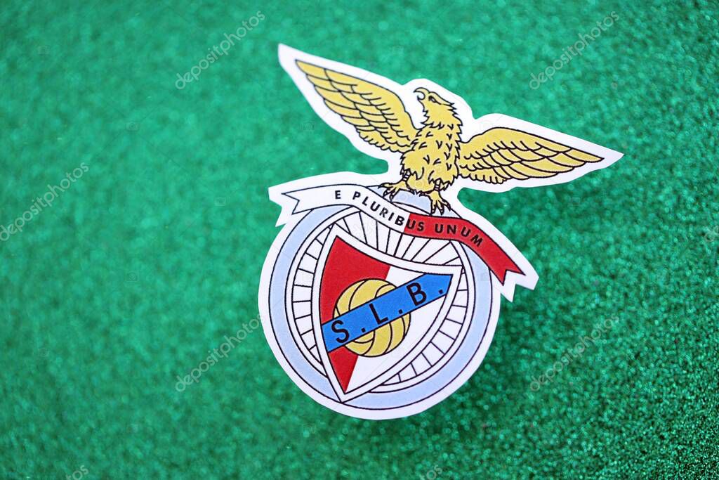 KYIV, UKRAINE - FEBRUARY 23, 2025 Sport Lisboa e Benfica football club badge lies on emerald green glitter background banner