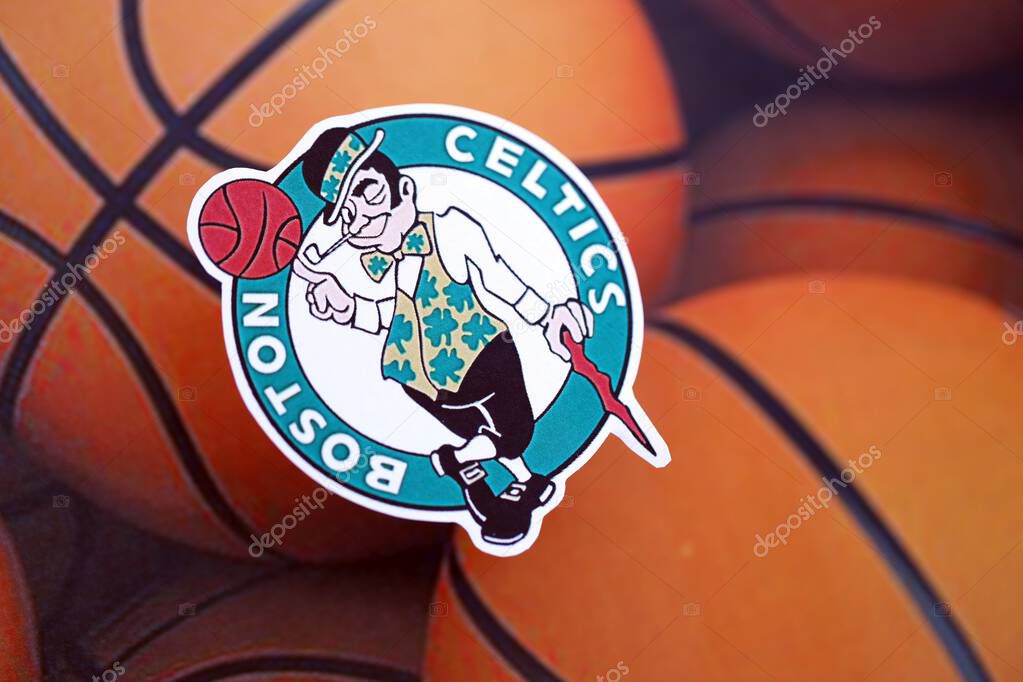 KYIV, UKRAINE - FEBRUARY 23, 2025 Boston Celtics basketball team badge lies on basketball balls background banner
