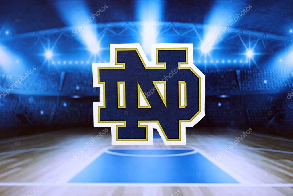 KYIV, UKRAINE - FEBRUARY 23, 2025 Notre Dame Fighting Irish basketball team badge lies on basketball stadium background banner