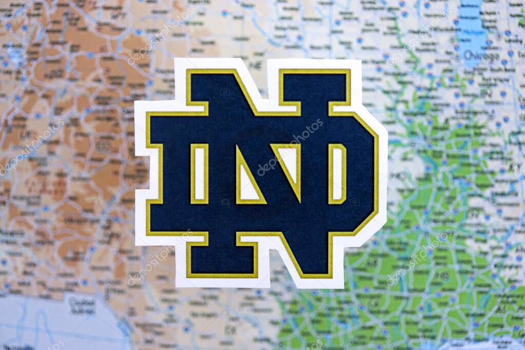 KYIV, UKRAINE - FEBRUARY 23, 2025 Notre Dame Fighting Irish basketball team badge lies on USA map background banner