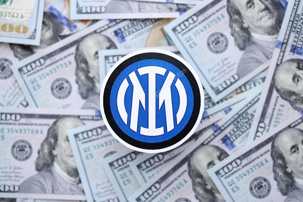 KYIV, UKRAINE - FEBRUARY 23, 2025 Inter Milan FC football club badge lies on big amount of hundred US dollar bills