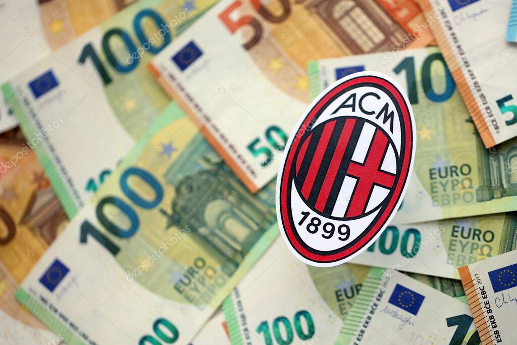 KYIV, UKRAINE - FEBRUARY 23, 2025 AC Milan football club badge lies on big amount of hundred EURO money bills