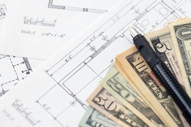 Kalemle birlikte yüklü miktarda Amerikan doları banknotları ve konut projesinin planları yakın plan. Yatırım ve inşaat projesi kavramı