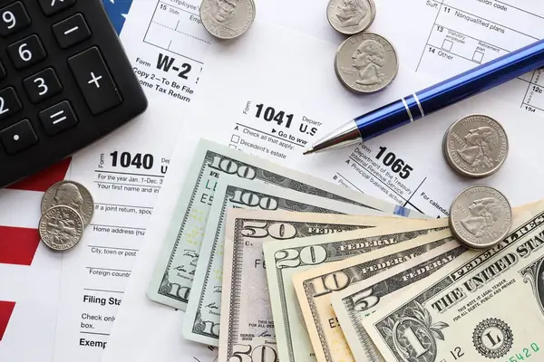 Amerikan Doları. Para banknotları ve vergi formundaki kalem ve hesap makineli paralar boş. Muhasebe ve vergi ödeme dönemi kavramı